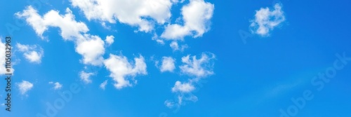 Softly scattered fluffy white clouds against a brilliant blue sky with just a few wispy strands, gentle weather, white clouds, blue sky