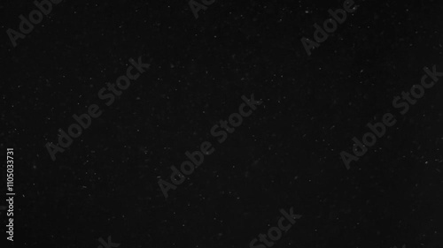Abstract bokeh of dust particles floating in the air on black background. Slow motion. Abstract animated overlay effect of white particles flying. Loop animation. 4k footage