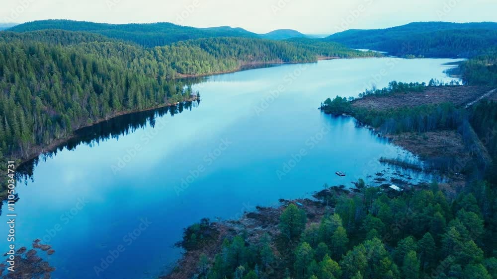 Aerial View Of Peaceful Lake Waters With Forest Reflections.