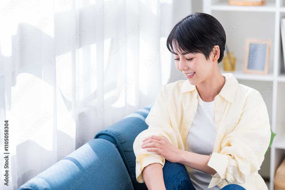 リビングでくつろぐ若い女性。
リビングでくつろぐ若い女性。