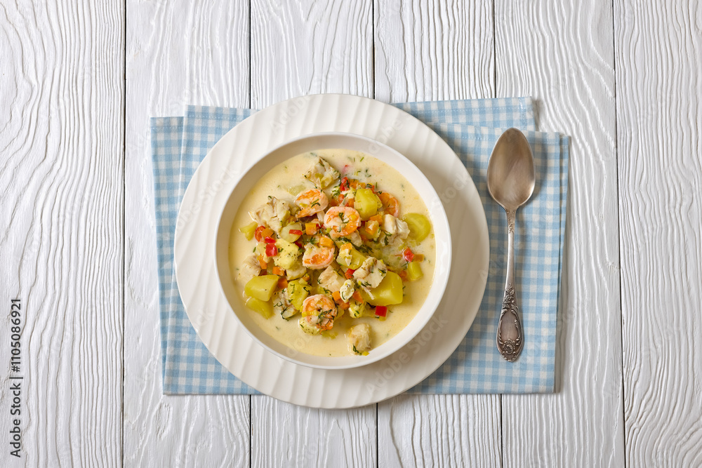 seafood chowder in a white bowl, top view seafood chowder in a white bowl, top view