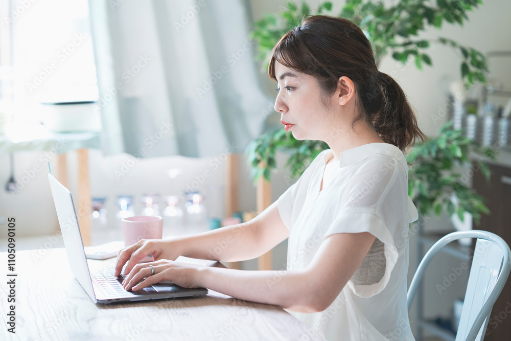 テレワークイメージ・自宅リビングで仕事をする女性 テレワークイメージ・自宅リビングで仕事をする女性