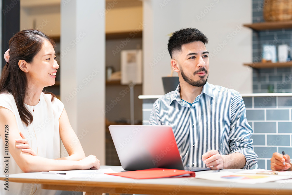 Obraz premium カジュアルな雰囲気のオフィス空間でミーティングするビジネスマンたち