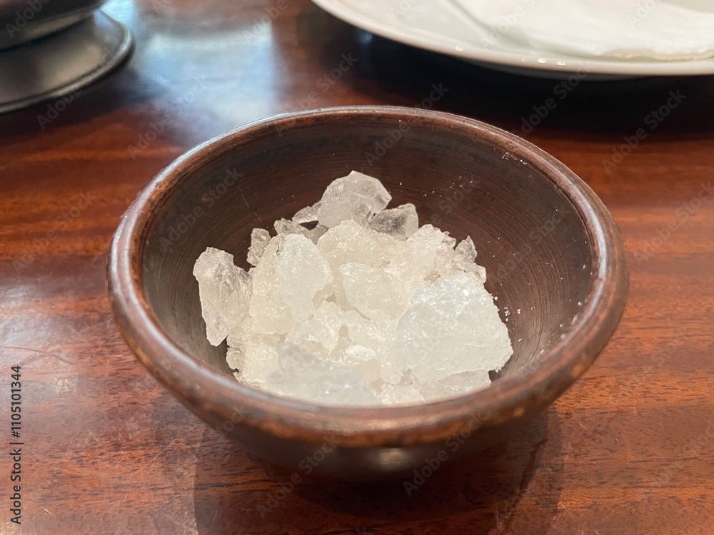 Closeup of Rock Candy Crystals in a Rustic Brown Bowl on a Wooden Table Closeup of Rock Candy Crystals in a Rustic Brown Bowl on a Wooden Table