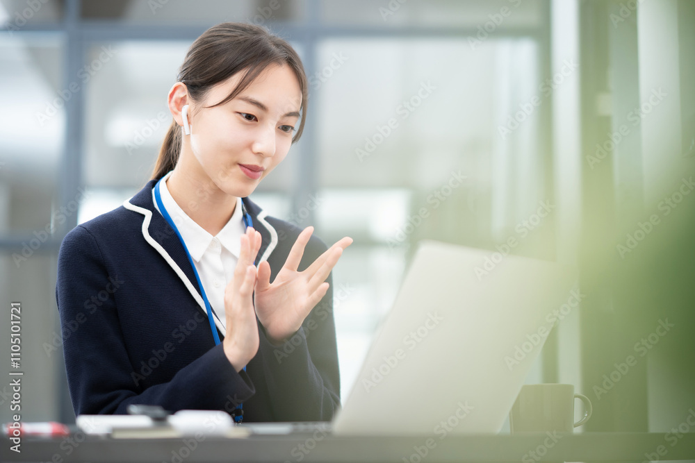 パソコンの画面に向かって話しかける女性 パソコンの画面に向かって話しかける女性