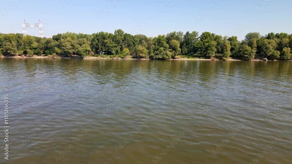 Scenic river view with lush greenery along the banks under clear blue skies Scenic river view with lush greenery along the banks under clear blue skies