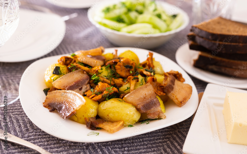 Baked potatoes with chanterelles and bacon served with herbs on white plate Baked potatoes with chanterelles and bacon served with herbs on white plate