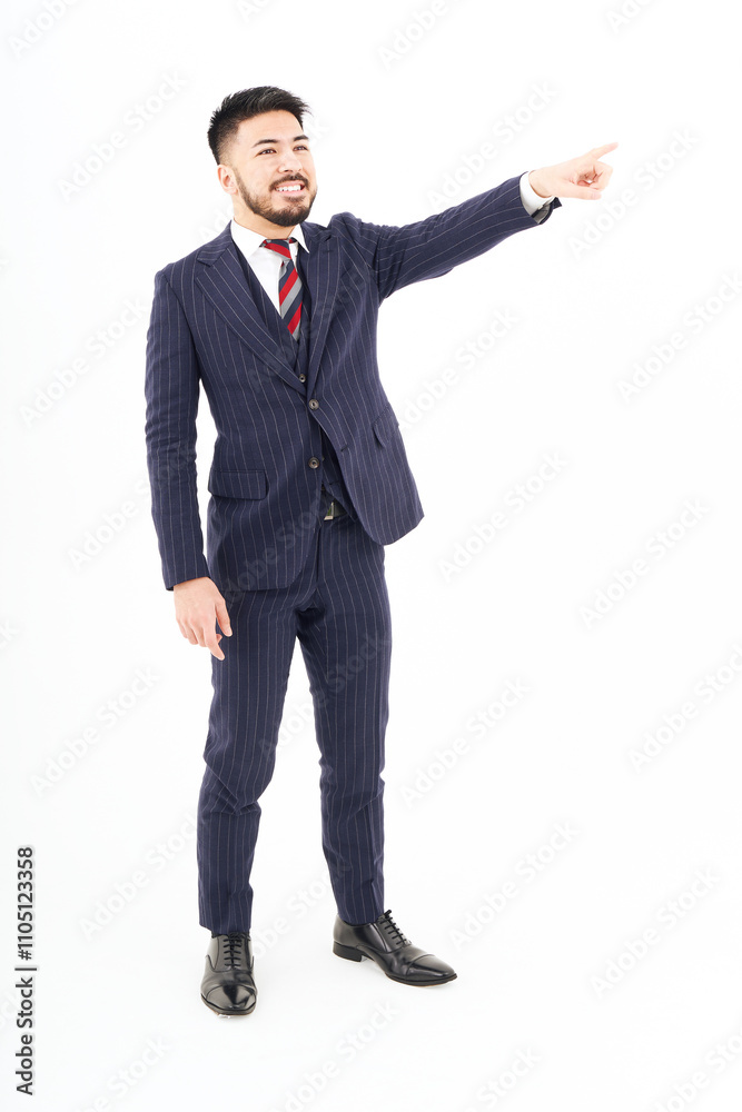 上の方を指差すスーツ姿の男性