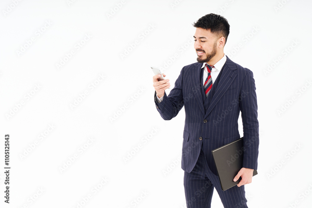 スマートフォンを操作するスーツ姿の男性 スマートフォンを操作するスーツ姿の男性
