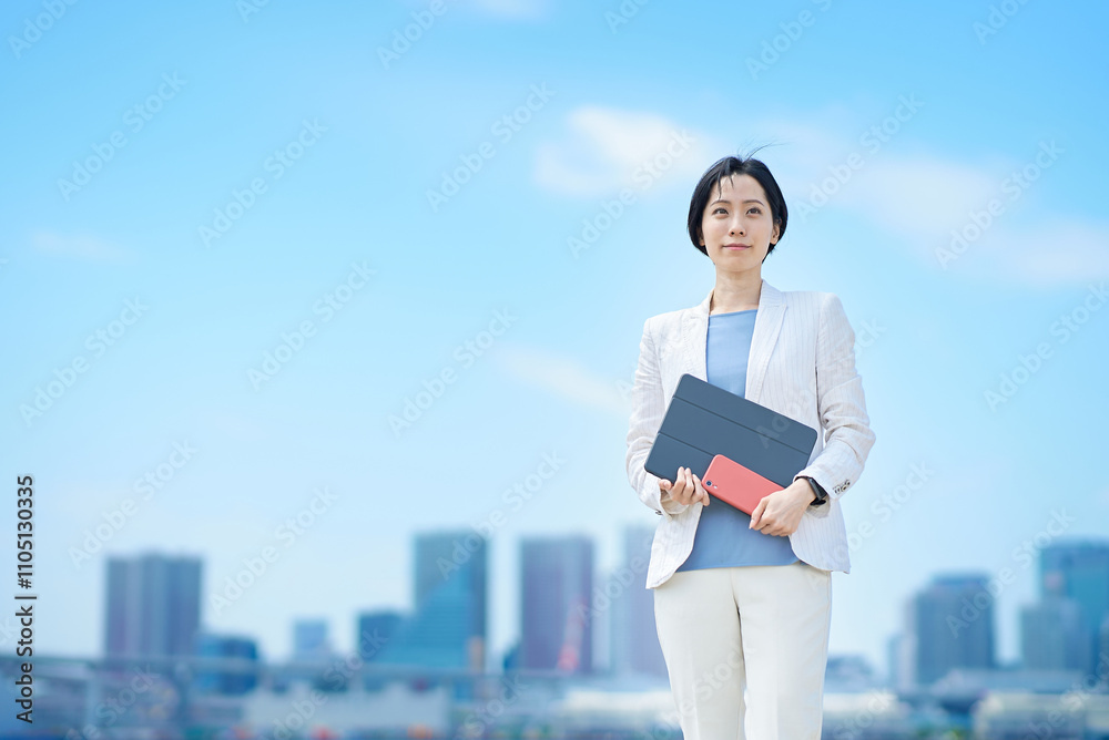 ビジネスウーマンと晴天の街並み