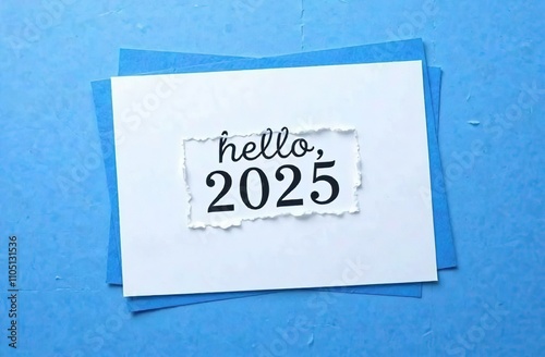 Hello, 2025, written on a torn piece of paper on a blue background. The conceptual symbol of the plan for 2025. A place to copy.