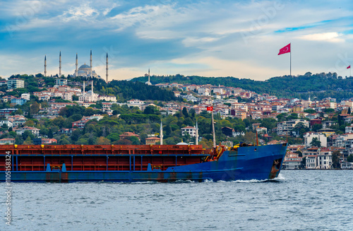 view from a pleasure boat on the Bosphorus and the cityscape of Istanbul, Turkey, the architecture of the city, a mosque and big Turkish flag on a flagpole photo