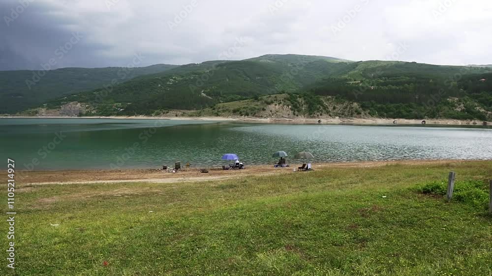 Enjoying a serene day at the lake with friends and family amidst lush hills and calm waters Enjoying a serene day at the lake with friends and family amidst lush hills and calm waters