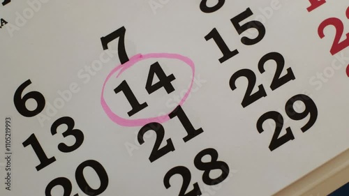 The 14 number in the calendar is marked with a marker as an important date. Close-up.