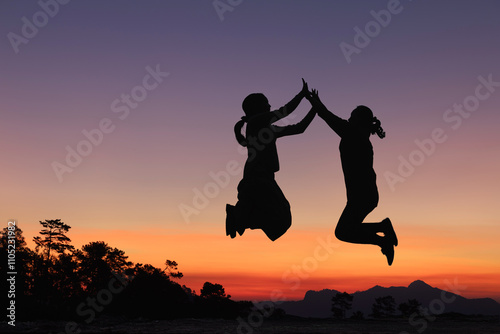 Принти на полотні Silhouette two girls traveler jump rejoice dance on mountain sunset colorful sky