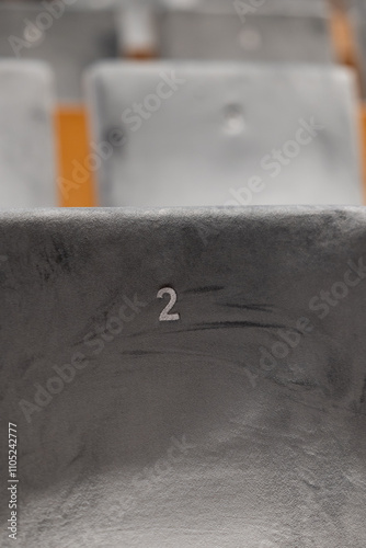 Obraz na płótnie Rows of empty seats in a cinema hall, front side of the seats with numbers. Close-up with shallow depth of field w salonie