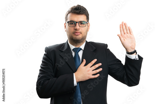 Serious businessman making honest oath gesture with palm on heart