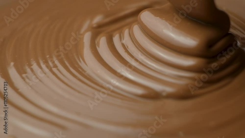 Melted milk chocolate pouring, chocolate texture, slow motion.