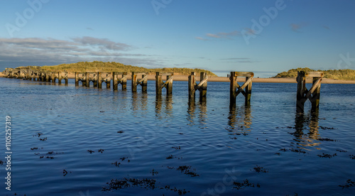 Remaining wooden supports of Lossiemouth old bridge in the water photo