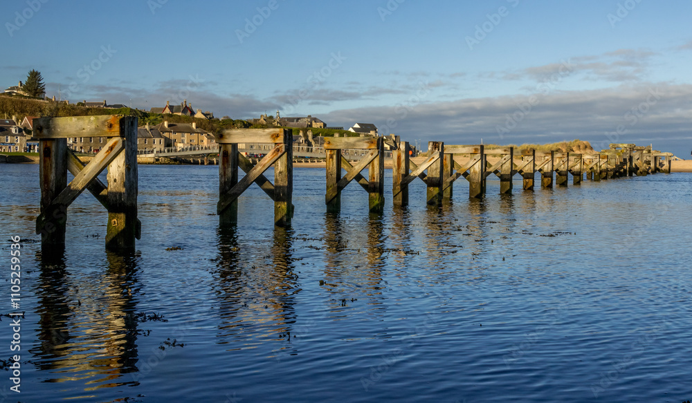 Remaining wooden supports of Lossiemouth old bridge in the water Remaining wooden supports of Lossiemouth old bridge in the water