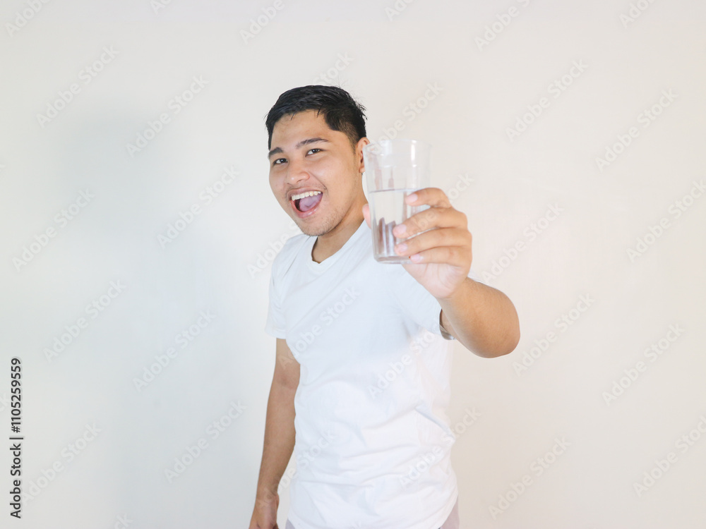 cheerfull Asian man shows a glass of water he is holding cheerfull Asian man shows a glass of water he is holding