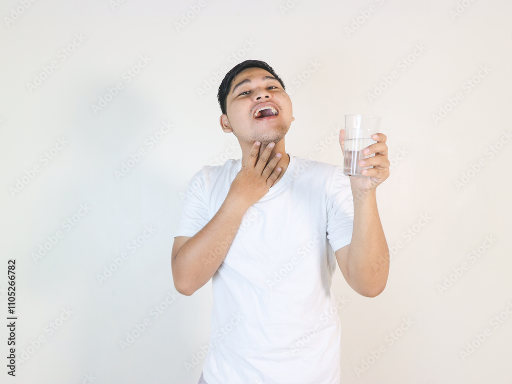 happy young asian man drinking water from glass over white background happy young asian man drinking water from glass over white background