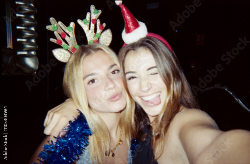 фотографія Two young women enjoying a festive Christmas party, wearing holiday accessories and smiling for the camera