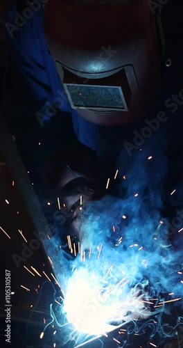 Welder at work in metal industry, welding metal construction - slow motion. Close-up shot lots of sparks in the factory