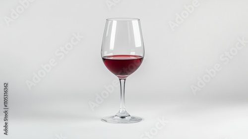 A tall glass of red wine against a soft, neutral background setting.