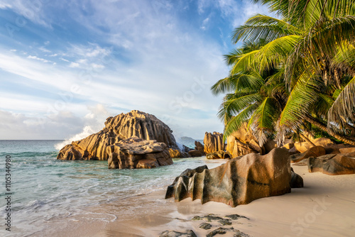 Granite rocks and palm trees on the scenic tropical sandy Anse Patates beach, La Digue island, Seychelles photo