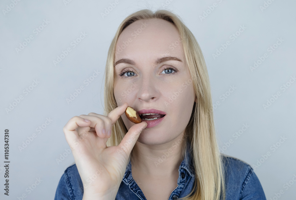 Prevention of thyroid diseases. Woman holds brazil nuts, rich in selenium, good for the thyroid gland Prevention of thyroid diseases. Woman holds brazil nuts, rich in selenium, good for the thyroid gland