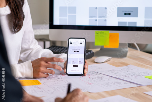 Tableau sur toile UX UI designer testing prototype on a phone, discussing and brainstorming on wireframes for a website and mobile app prototype, in the concept of website and mobile application design concept