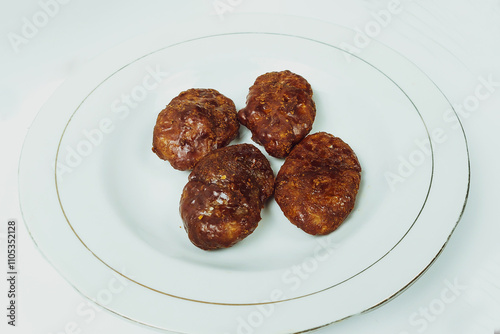 Taripang cake on a white plate on a plain white table in the dining room photo