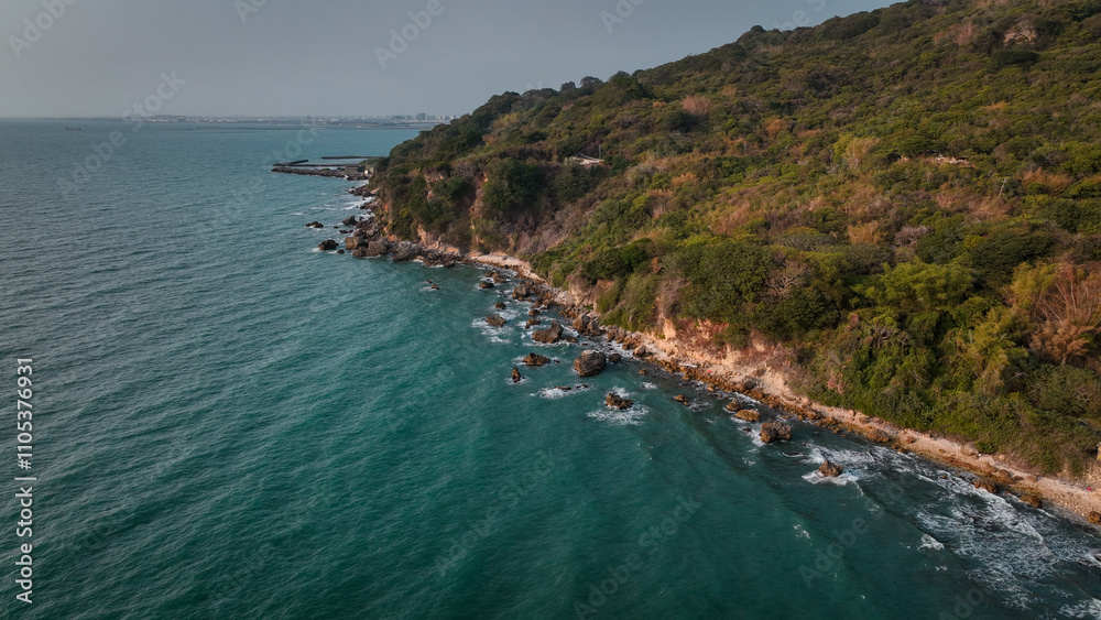 Obraz premium Taiwan coast features a rocky shoreline and lush greenery by tranquil blue waters