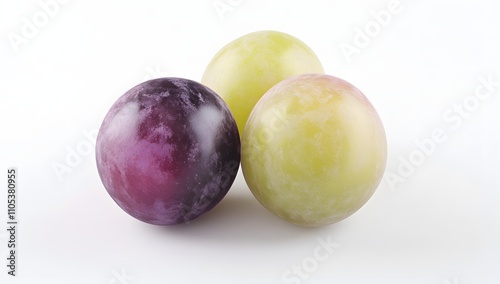 Three plump grapes, one dark purple, two pale green-yellow, rest on a pristine white background. A still life showcasing the beauty of fresh fruit.