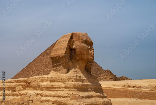Great Sphinx in front of Pyramid of Cheops (Khufu). Giza Pyramid Complex is complex of ancient monuments on Giza Plateau in suburbs of modern capital of Egypt. Cairo, Egypt - April 18, 2008