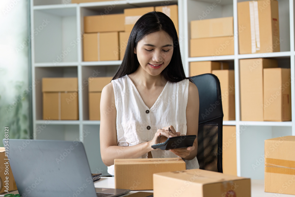 Young Entrepreneur Managing Online Business from Home Office Surrounded by Shipping Boxes and Laptop Young Entrepreneur Managing Online Business from Home Office Surrounded by Shipping Boxes and Laptop