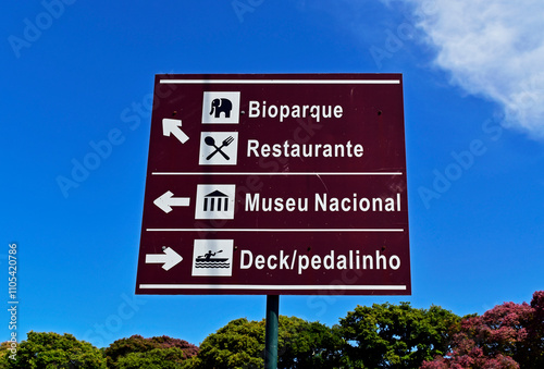 Obraz na płótnie Traffic sign indicating the way to the bio park, restaurant, National Museum and pedal boats in Quinta da Boa Vista, Rio, Brazil w salonie