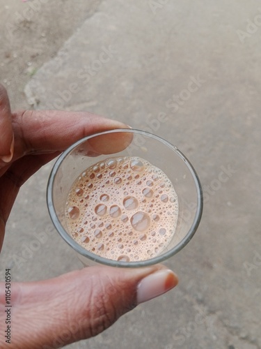 hand holding a glass of tea