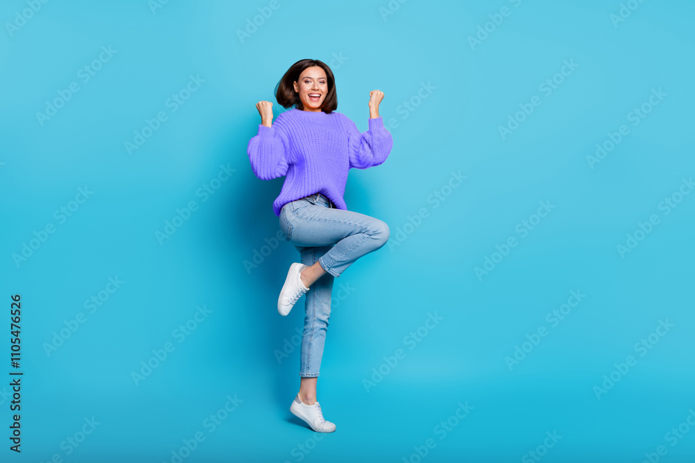 Full length body size view of attractive cheerful lucky girl jumping dancing rejoicing isolated over bright blue color background Full length body size view of attractive cheerful lucky girl jumping dancing rejoicing isolated over bright blue color background
