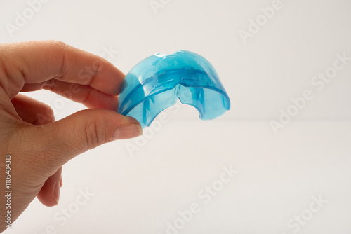 Hand holds dental simulator for teeth alignment. dental trainer equalize growing teeth, correct bite Teen and child orthodontic oral health care concept. Mouthguard, brace