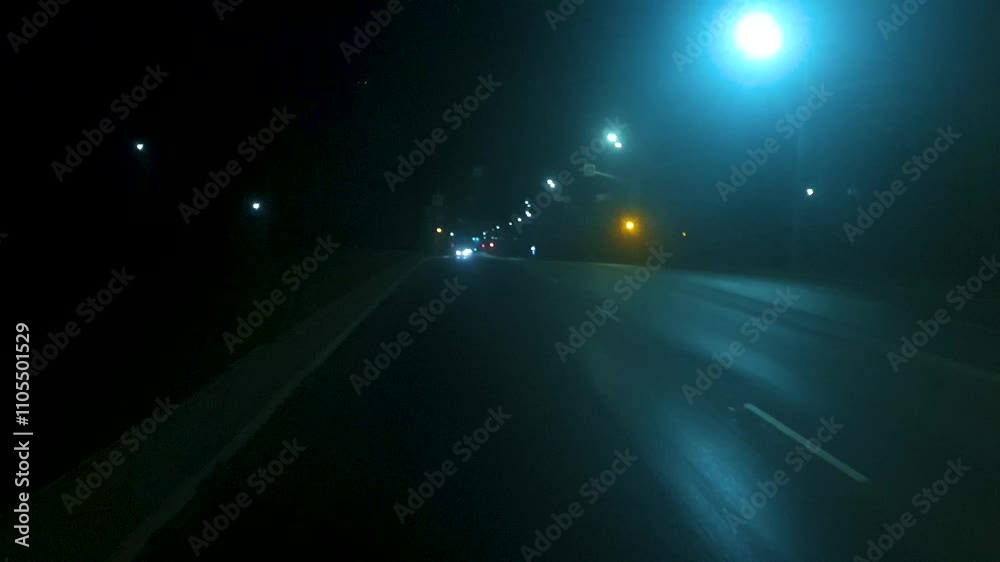 Driving in fog on a paved road in the darkness,a mysterious path with road lighting in the darkness of night.