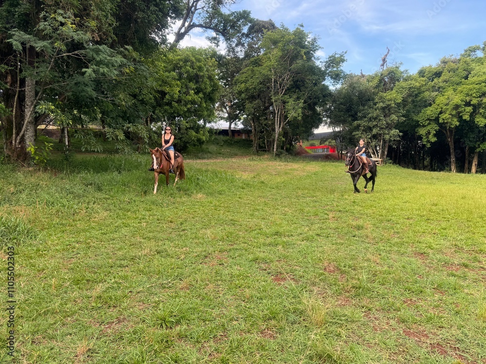 mãe e filha andam de cavalo no bosque 