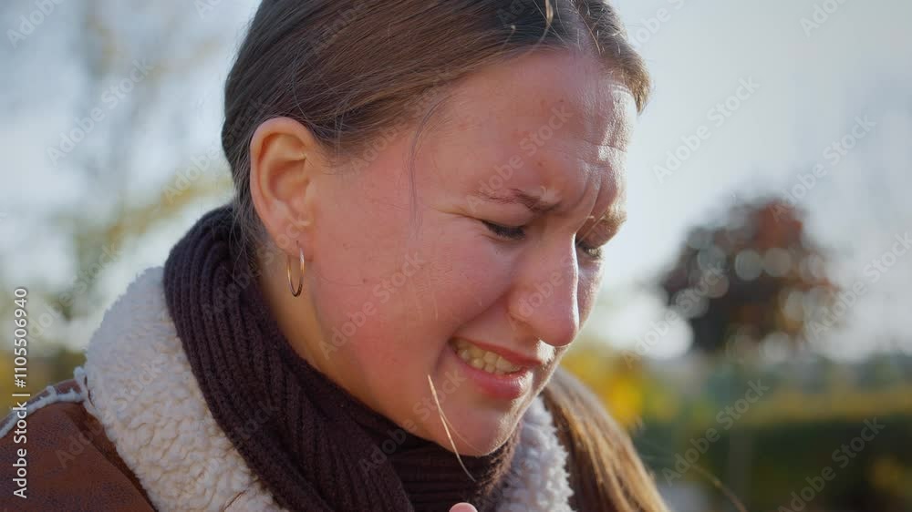 Young woman expressing various signs of pain and discomfort due to toothache. Facial expressions reveal intensity of suffering impact on her well-being. In park on bench in open air.