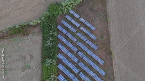 installation of solar panels on a hill with crops on the side in Italy at sunset with view from the top