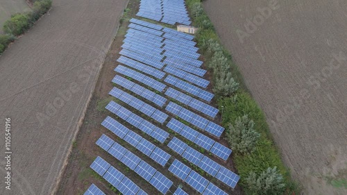 installation of solar panels on a hill with crops on the side in Italy at sunset with view from the top