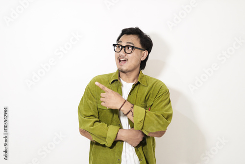 Adult Asian man pointing finger to the right with smiling face isolated on white background