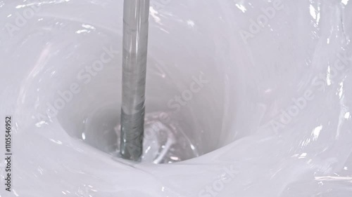 Industrial mixer creating whirlpool in white paint