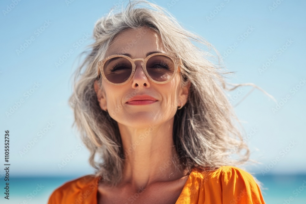 Woman with gray hair enjoying a sunny beach day and smiling at the camera Woman with gray hair enjoying a sunny beach day and smiling at the camera