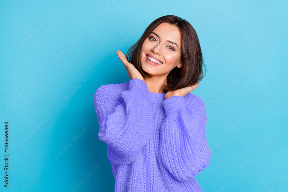 Fototapeta premium Portrait of attractive cheerful well-groomed girl touching soft smooth hair isolated over bright blue color background